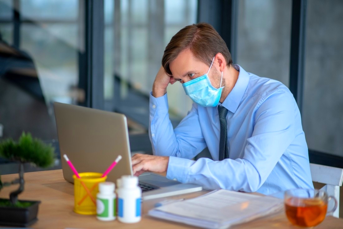 Employé de bureau muni d'un masque face au coronavirus