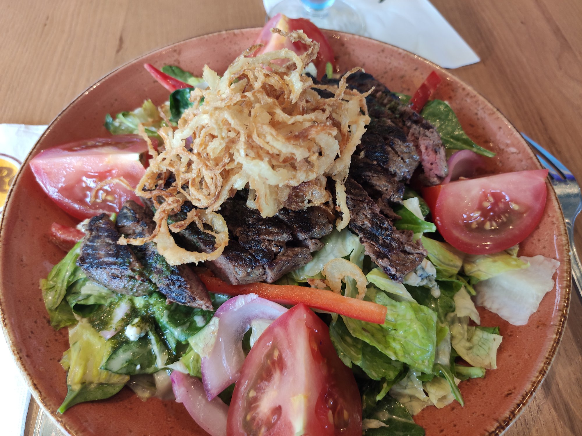 Parmi les succès de la nouvelle carte, la steak salad, très réussie : tranches de bœuf grillées sur un lit de salades mélangées, vinaigrette au fromage bleu, oignons rouges croustillants, poivrons rouges, tomates , oignons grilles et d’éclats de fromage bleu