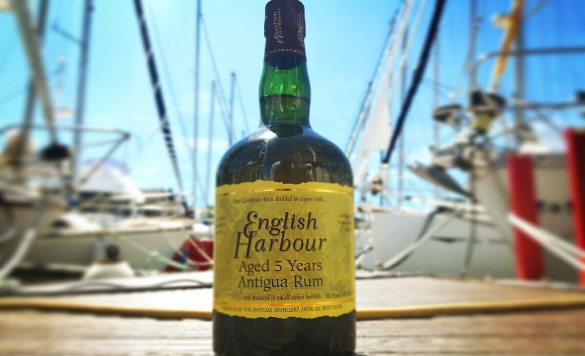 Rhum English Harbour 5yo sur un port avec un voilier